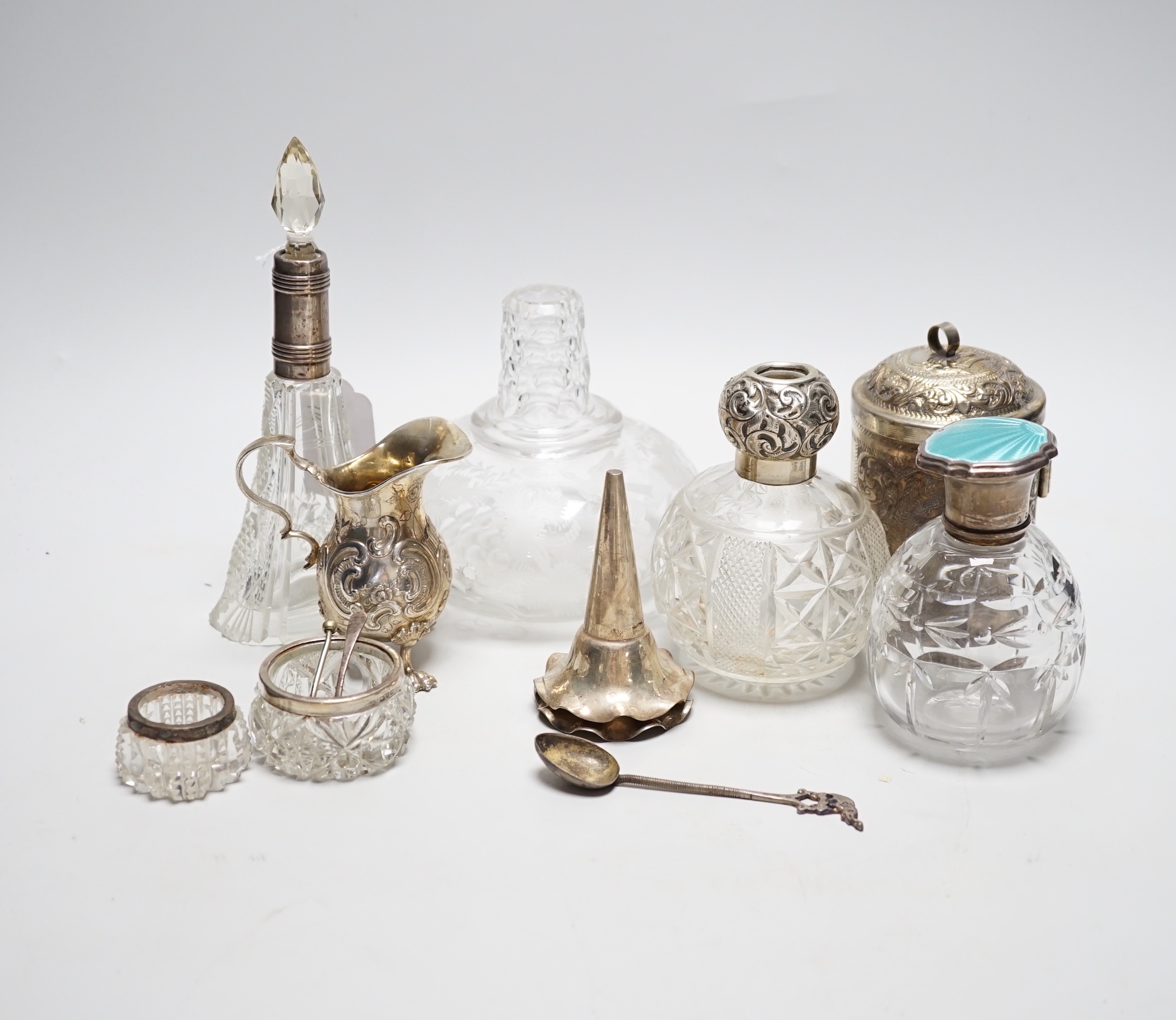Sundry items including a German 800 white metal cream jug, three mounted glass scent bottles including silver and enamel, Indian white metal cannister, etched glass decanter, etc.